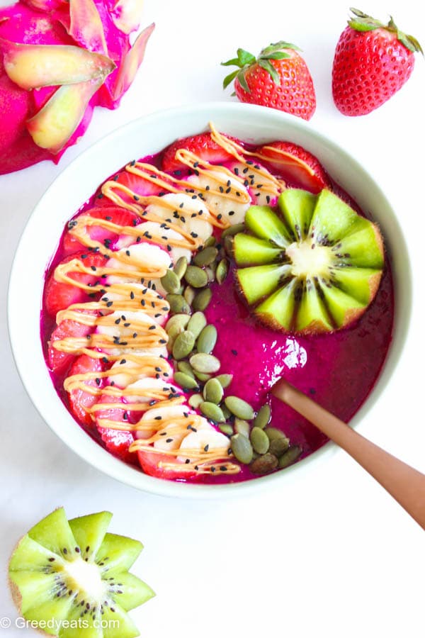 Dragon fruit smoothie bowl with fruits and seeds toppings