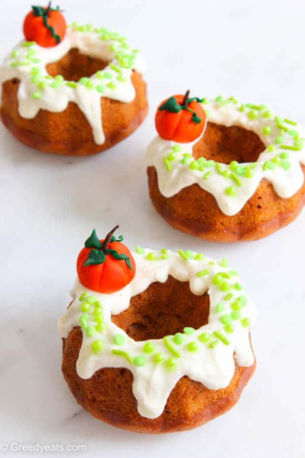 Mini Pumpkin Cakes with cream cheese icing, fall sprinkles and pumpkin toppers.