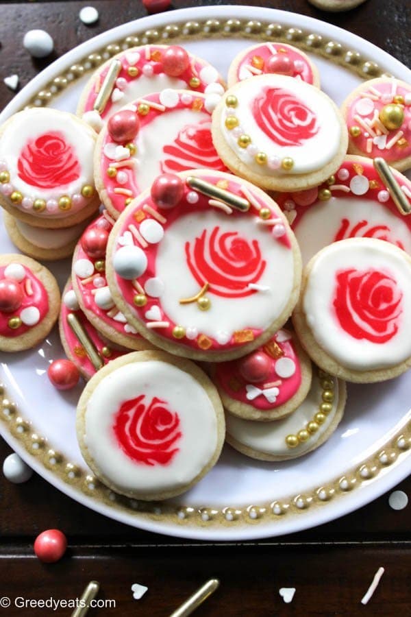 Easy cut out sugar cookie recipe decorated as rose cookies is perfect for valentines! These cookies are topped with royal icing and sprinkles.