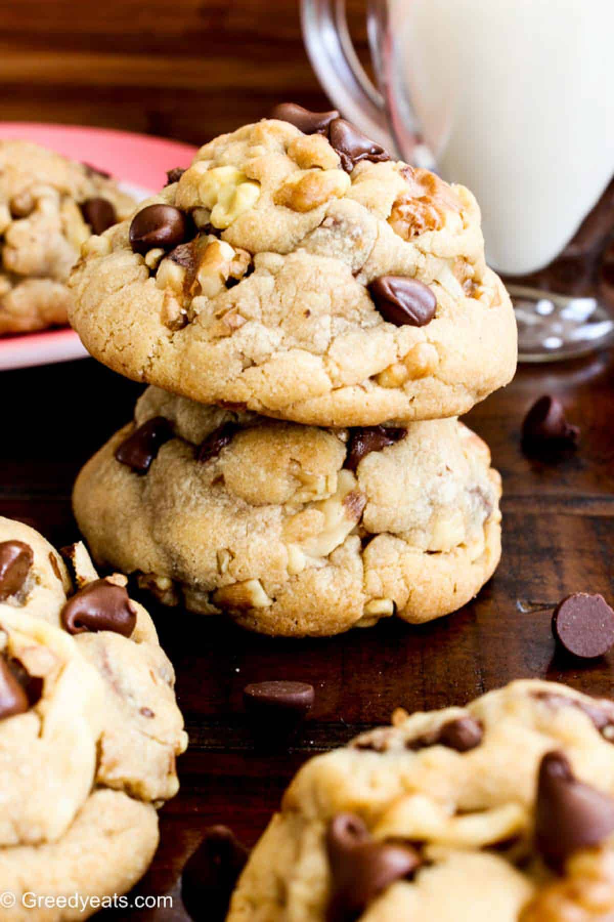 Chewy and ultra thick chocolate chip walnut cookies with soft centers kept on a wooden table.