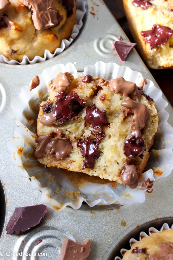 Made with zero refined sugar, sweetend with honey, packed with good fats and protein rich greek yogurt, this healthy banana muffin recipe is a keeper! Soft, fluffy and oozing with gooey chocolate banana muffins recipe at Greedyeats.com