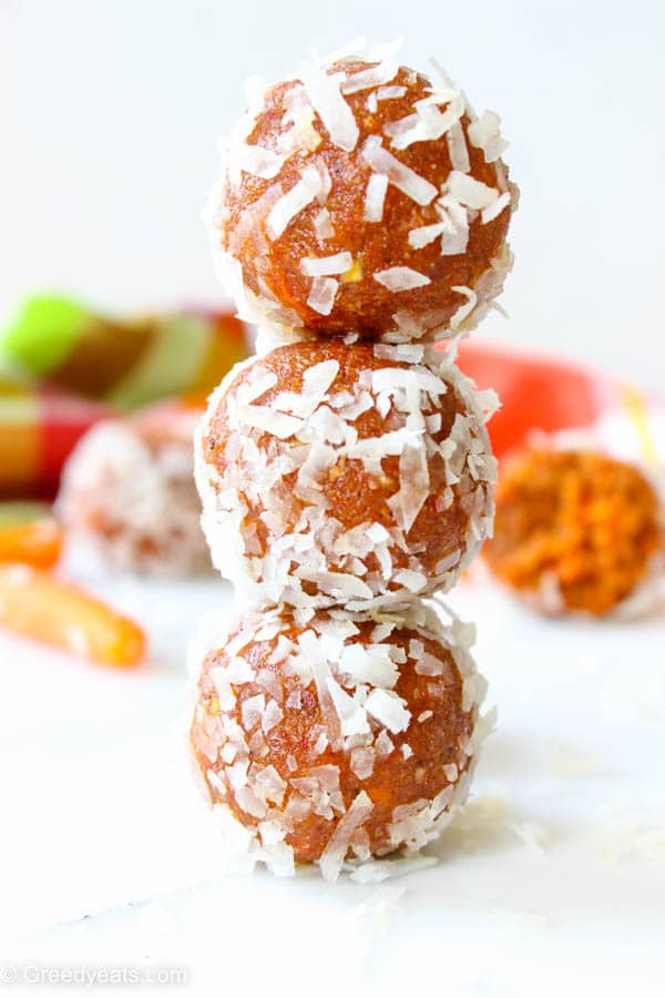 A stack of coconut coated Carrot Cake Balls filled with spiced carrot cake flavors.