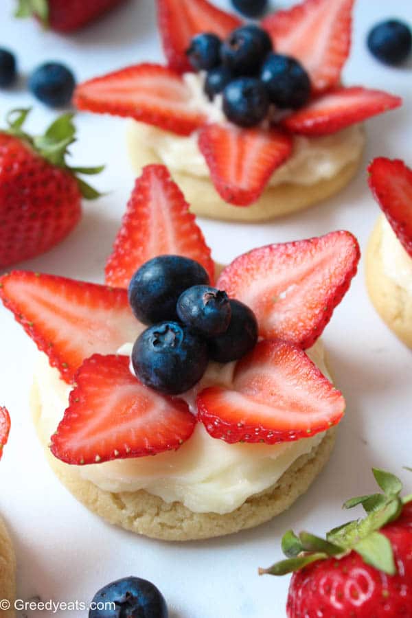 Mini version of a sugar cookie pizza! These mini fruit pizza sugar cookies are so chewy and refreshing from lemon cream cheese frotsing and fresh berries.