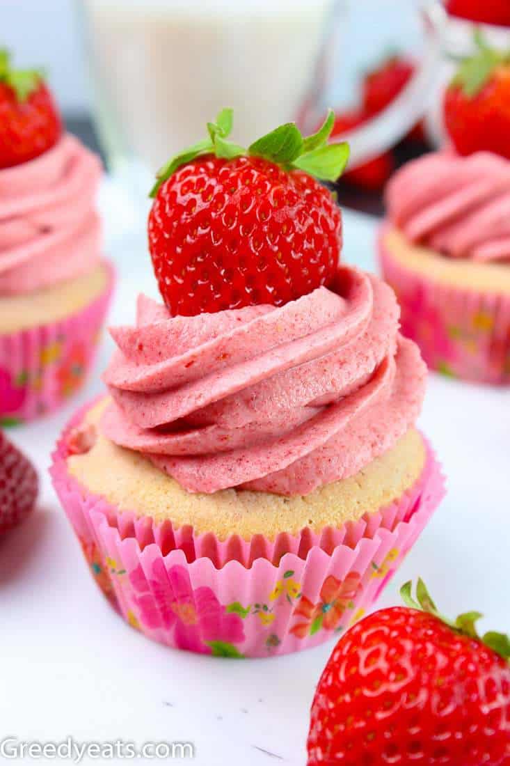 Soft and fluffy Strawberry Cupcakes on a pink cupcake liner. These are topped with pink and creamy strawberry Buttercream.