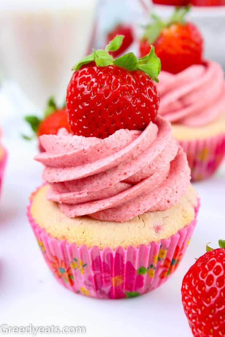 Soft, springy Strawberry Cupcake recipe with Strawberry Buttercream and a fresh Strawberry.