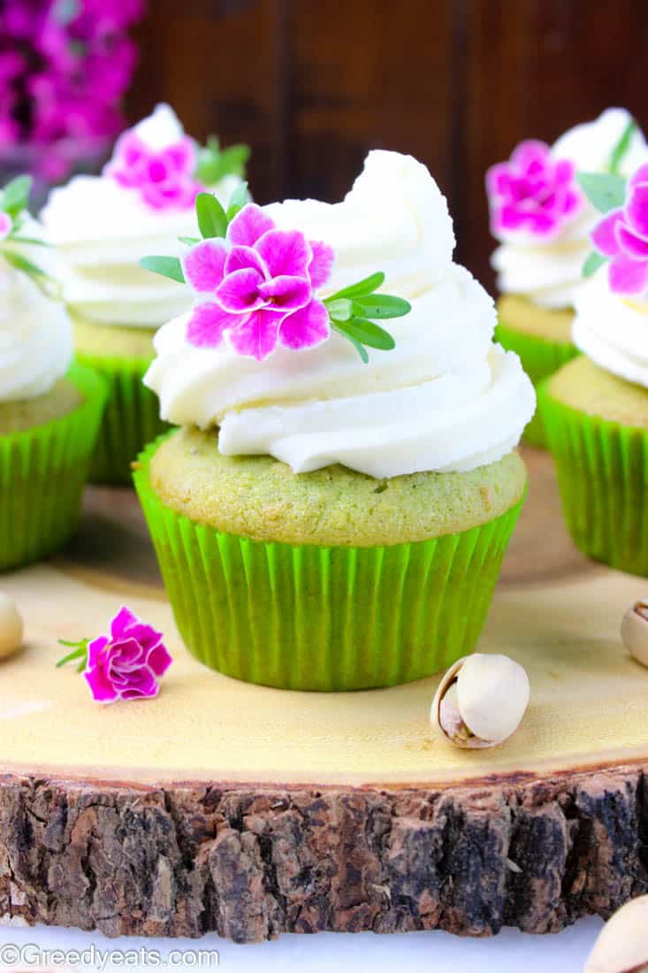 Soft and fluffy pistachio cupcakes frosted with creamy vanilla butter frosting