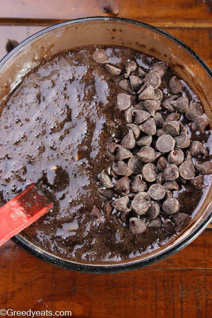 Chocolate Muffin batter in a glazz mixing bowl with chocolate chips.