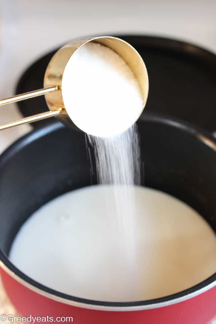 Mixing sugar with Milk in a pot.