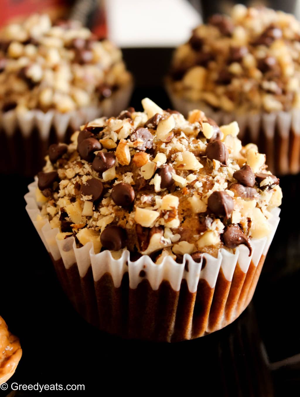 Whole wheat coffee muffins with walnuts and chocolate chips in a muffin liner.