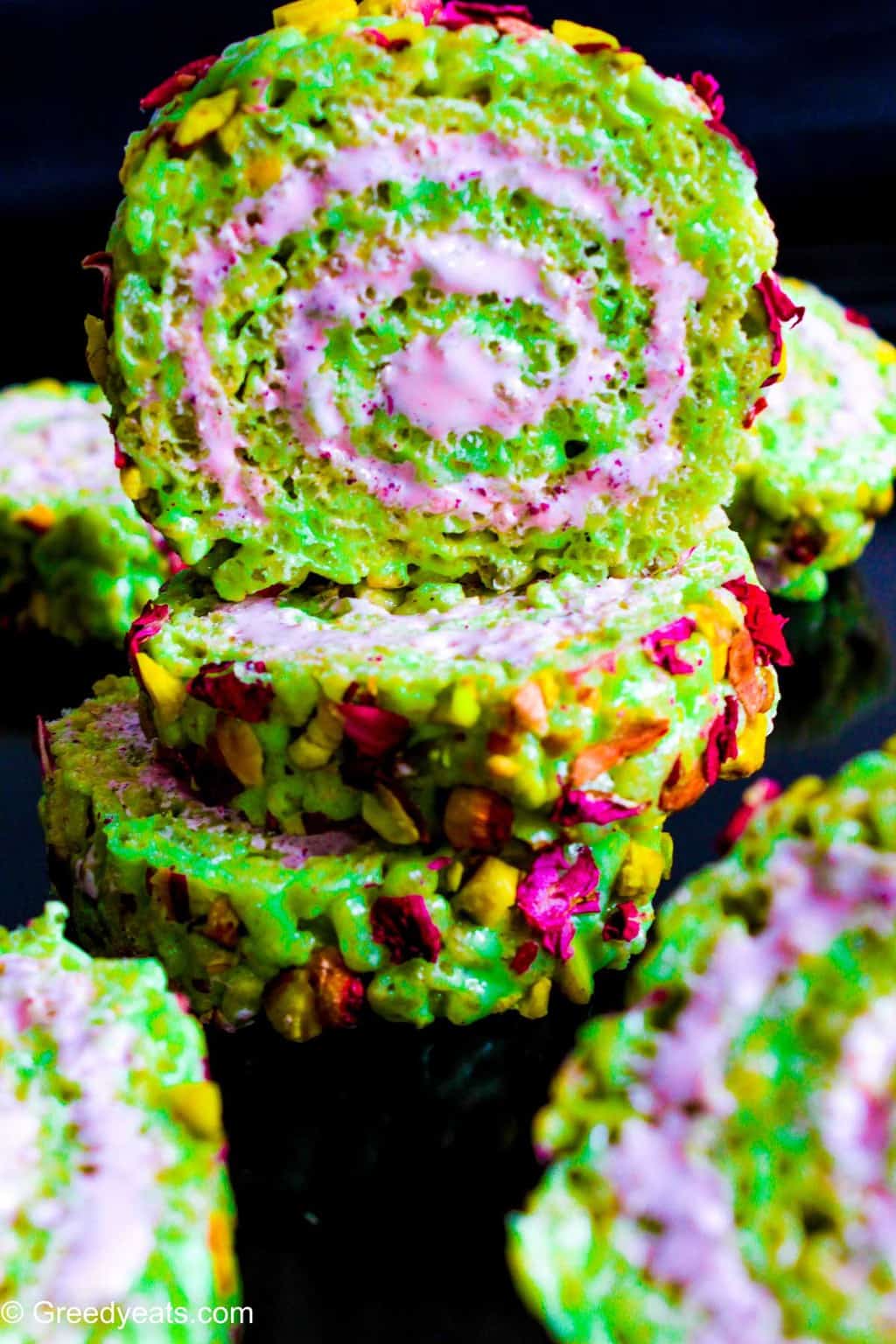 Easy Rice Krispie Treat slices swirled with marshmallow fluff and topped with real pistachio chunks.