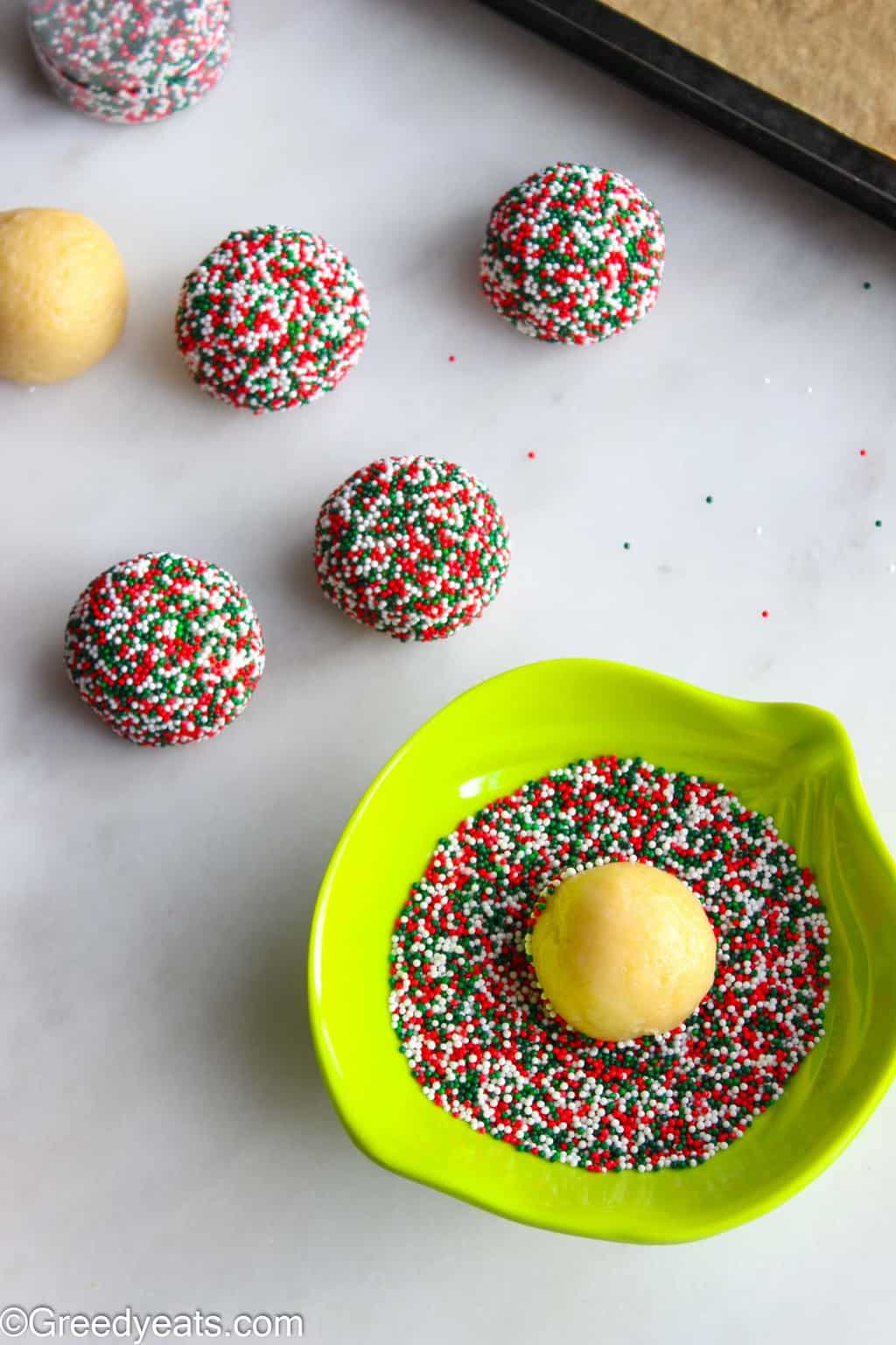 Soft sugar cookie dough balls rolled in Christmas sprinkles