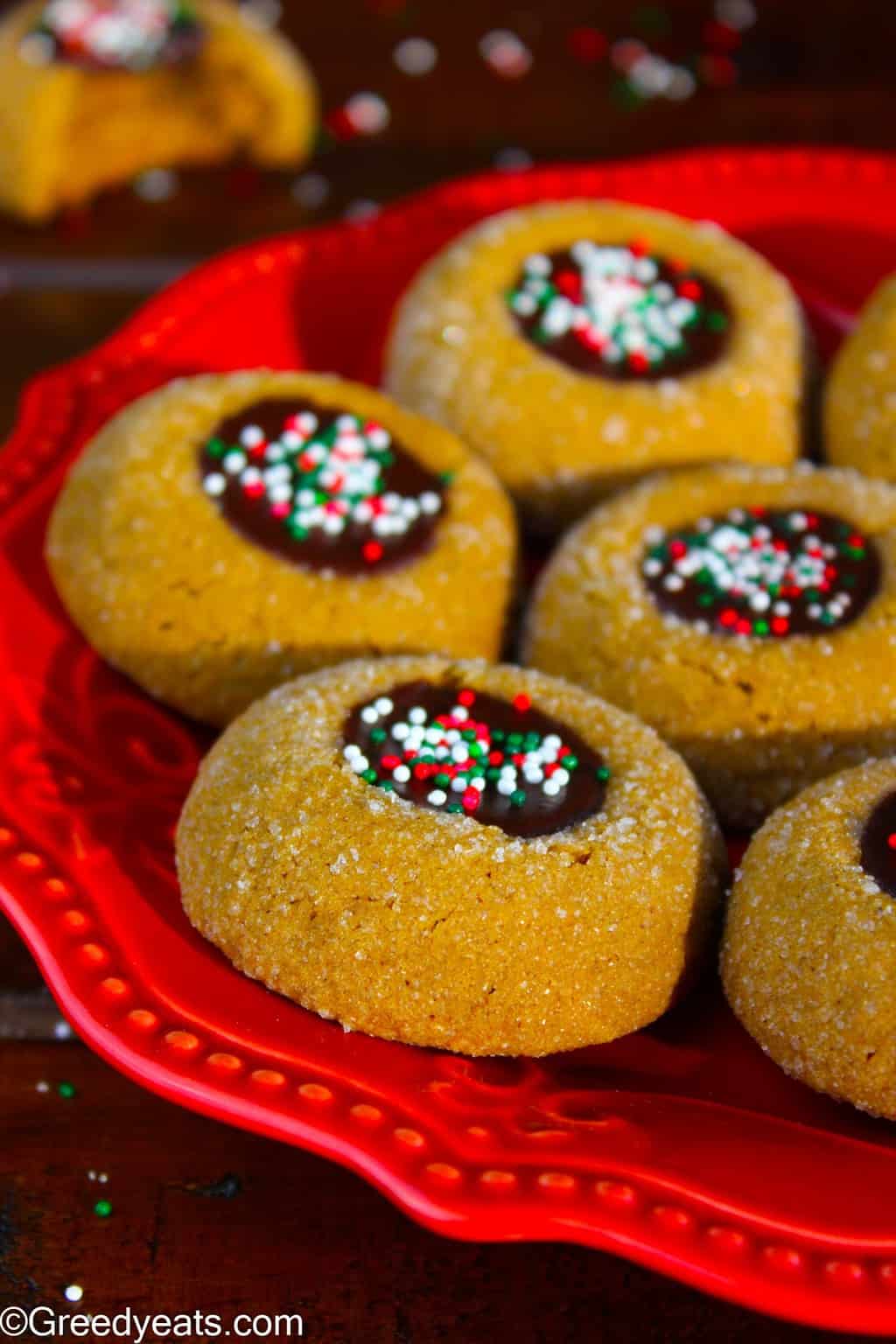 Molasses thumbprint cookies with chocolate ganache and christmas sprinkles.