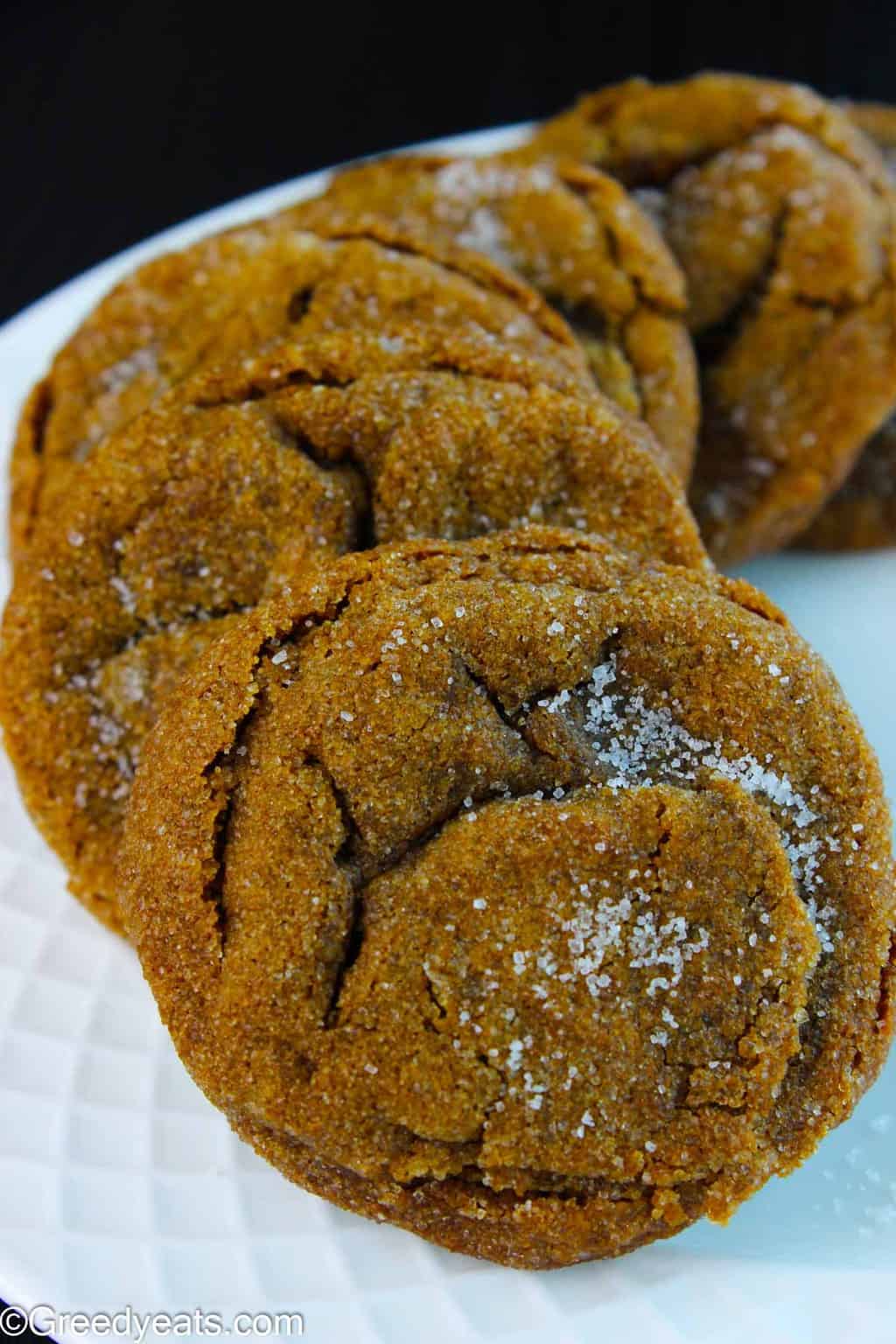 Soft and easy molasses cookies spreaded on a white plate.
