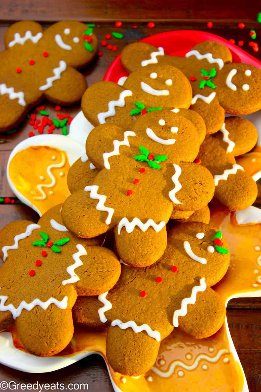 Gingerbread man cookies decorated with vanilla icing and christmas sprinkles.