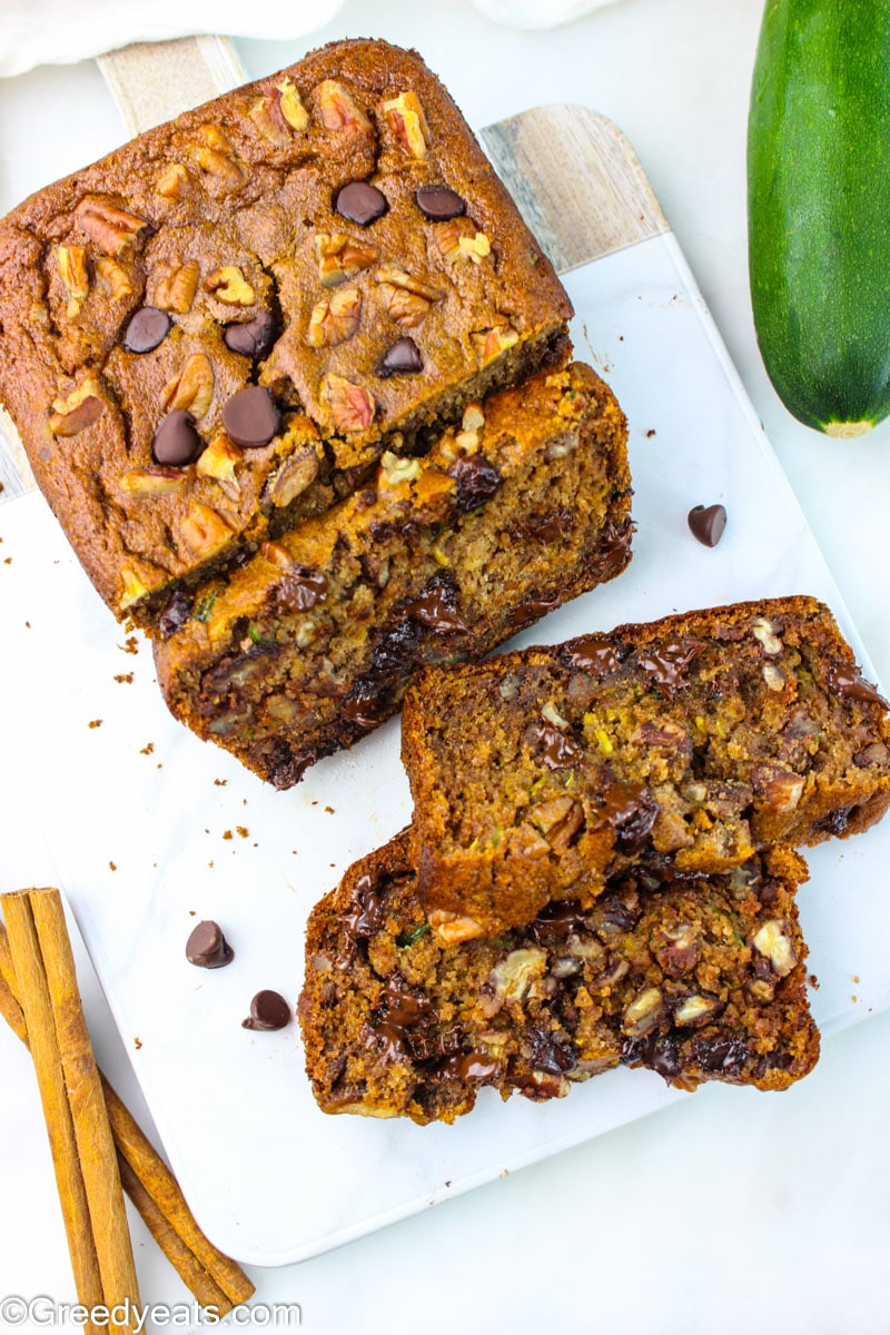 No flour zucchini bread dotted with pecans and chocolate chips on a white board.