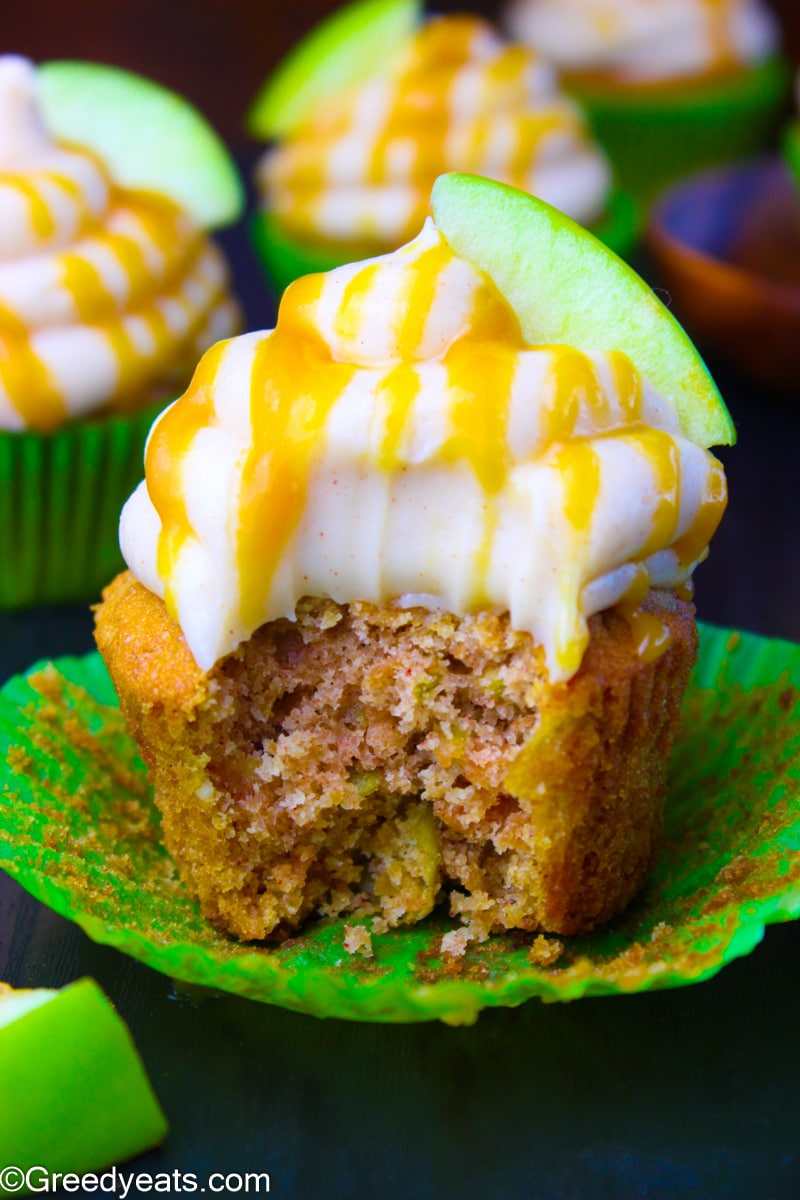 Perfectly spiced and soft fall cupcakes topped with cream cheese frosting in a green wrapper.