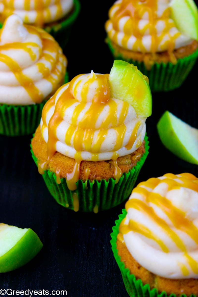 Caramel glazed Apple cupcakes with cream cheese frosting topped with fresh green apples.