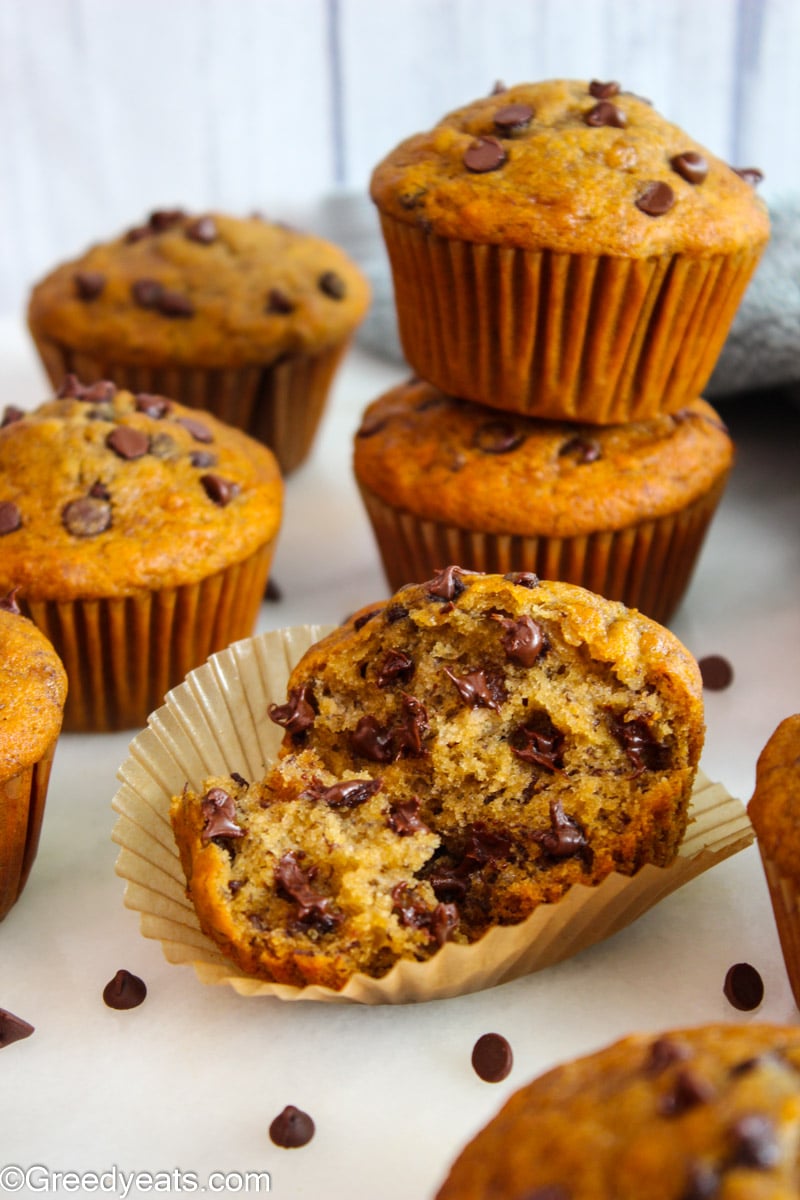 Soft and tender whole wheat banana muffins with mini chocolate chips stacked.