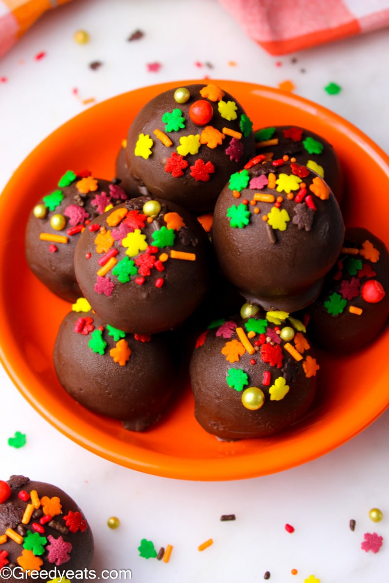 Pumpkin Cake Balls stack dipped in dark melted chocolate and topped with fall sprinkles.