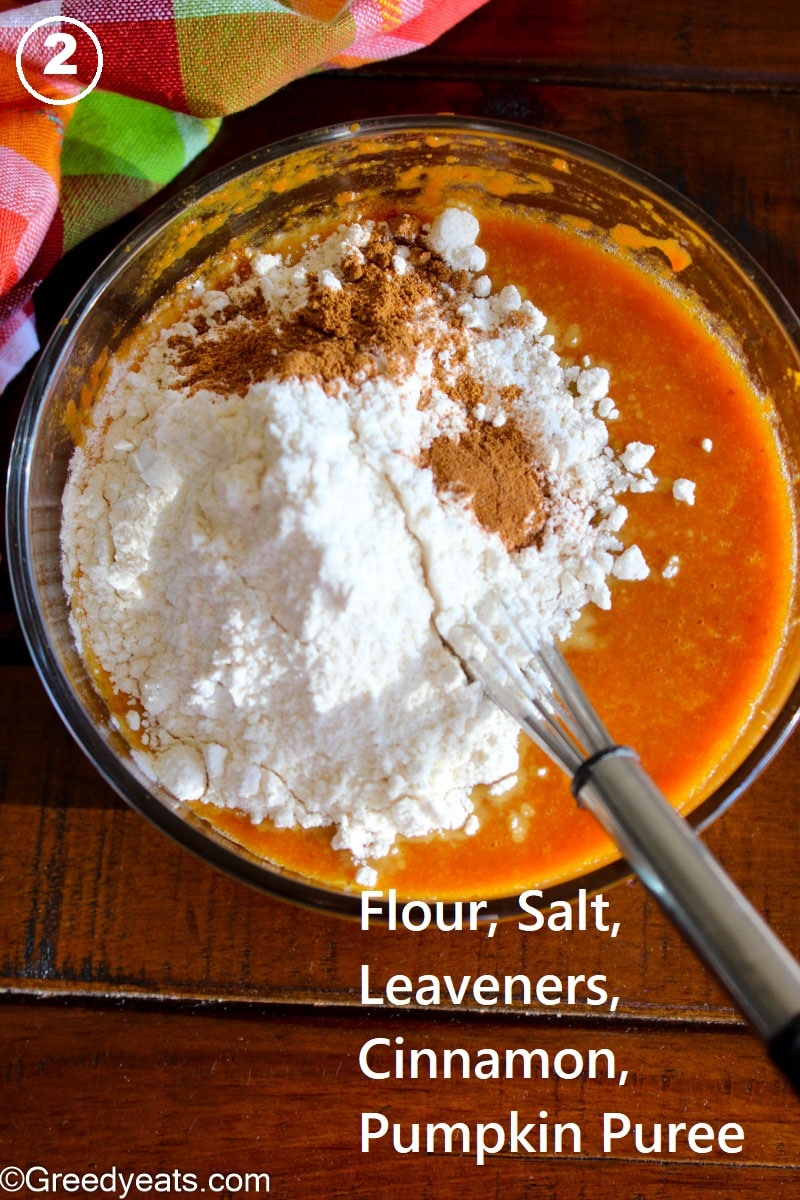Dry ingredients over wet in a mixing bowl for pumpkin bars batter.