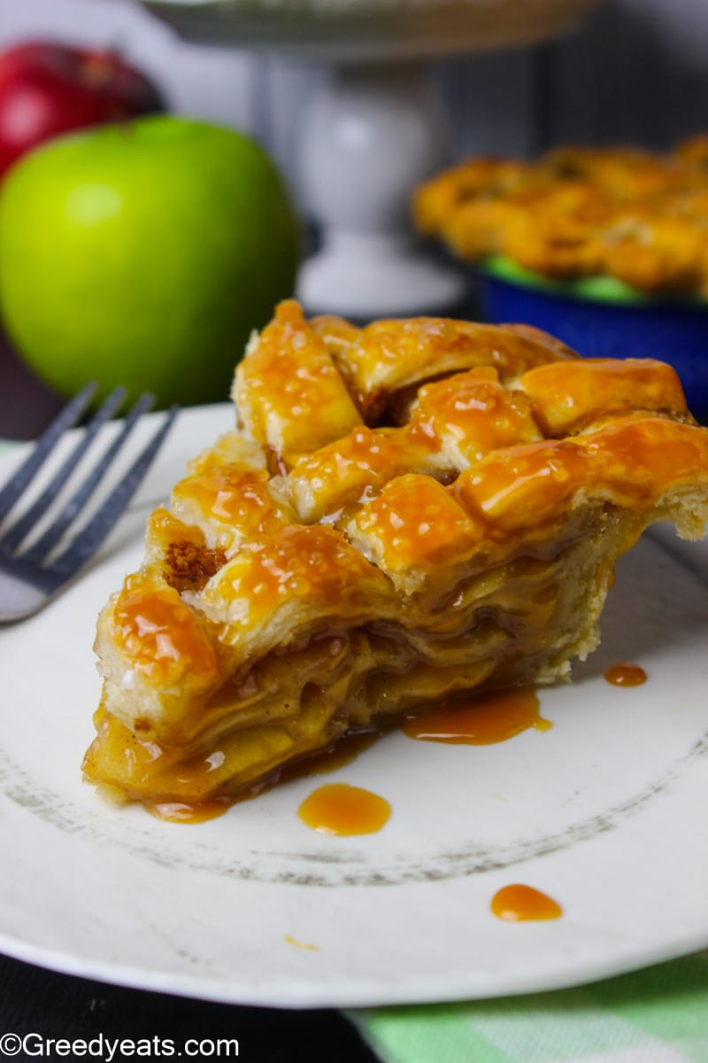 A slice of Apple Pie baked with lattice pie crust and homemade apple pie filling.