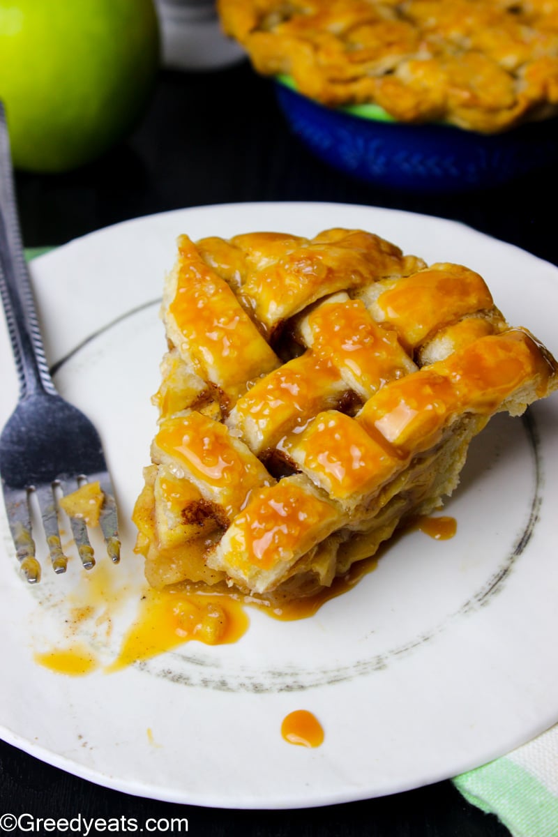 A slice of Apple Pie baked with lattice pie design,drizzled with caramel. 