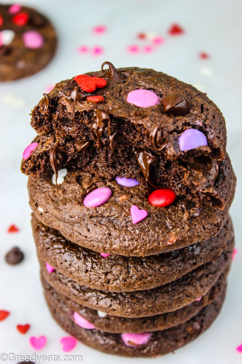 A stack of thick and chewy chocolate brownie cookies dotted with melty chocolate cookies.