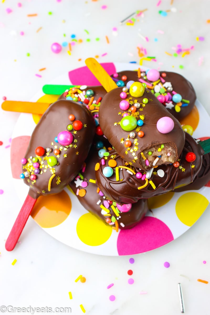 Cake popsicles dipped in milk chocolate and topped with stars and sprinkles.