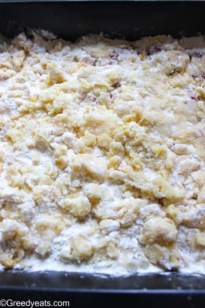 Unbaked cake crumbs, mixed with melted butter in a baking pan.