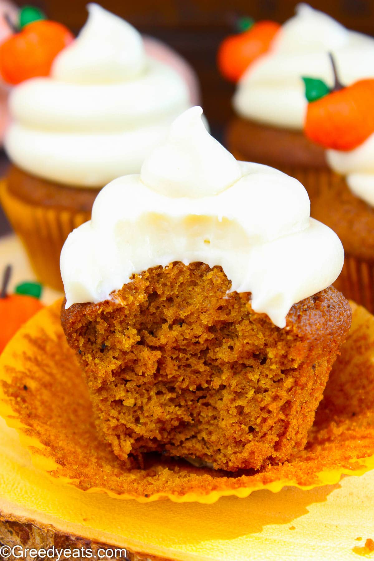 Super moist and easy Pumpkin Cupcake Recipe topped with creamy frosting in a wrapper.
