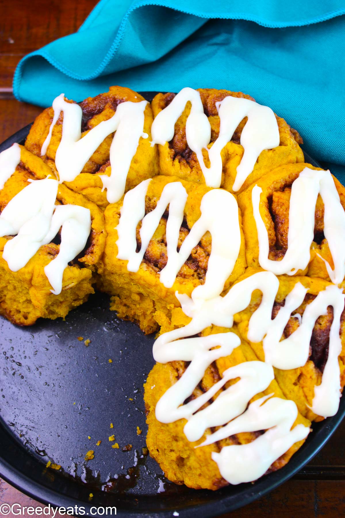 Homemade Pumpkin Rolls topped with creamy and sweet cream cheese icing.