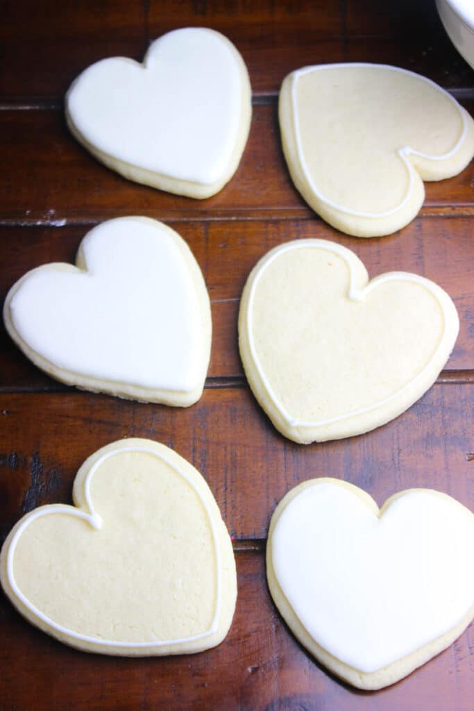 Baked sugar cookies in heart shapes and topped with royal icing.