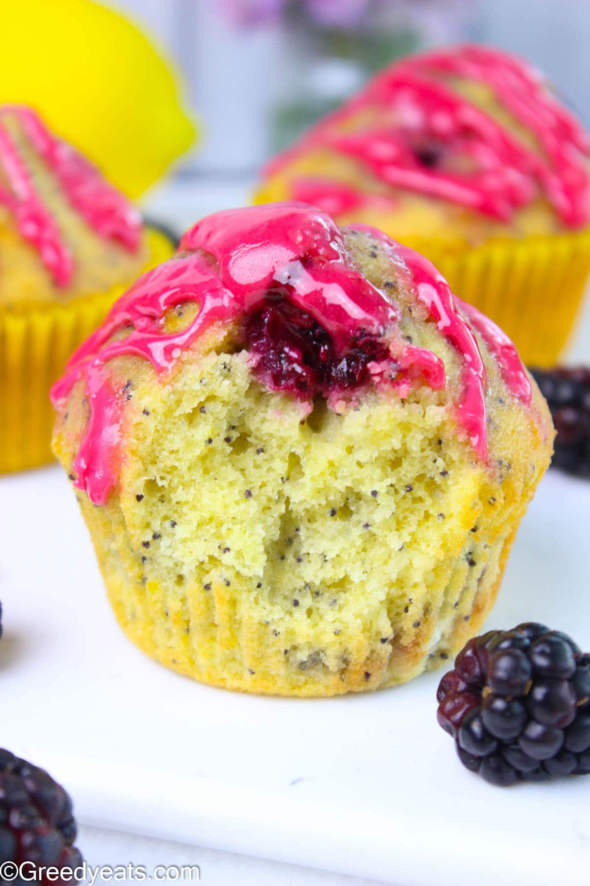 Soft, tall, light and fruity lemon poppyseed muffins topped with blackberry glaze