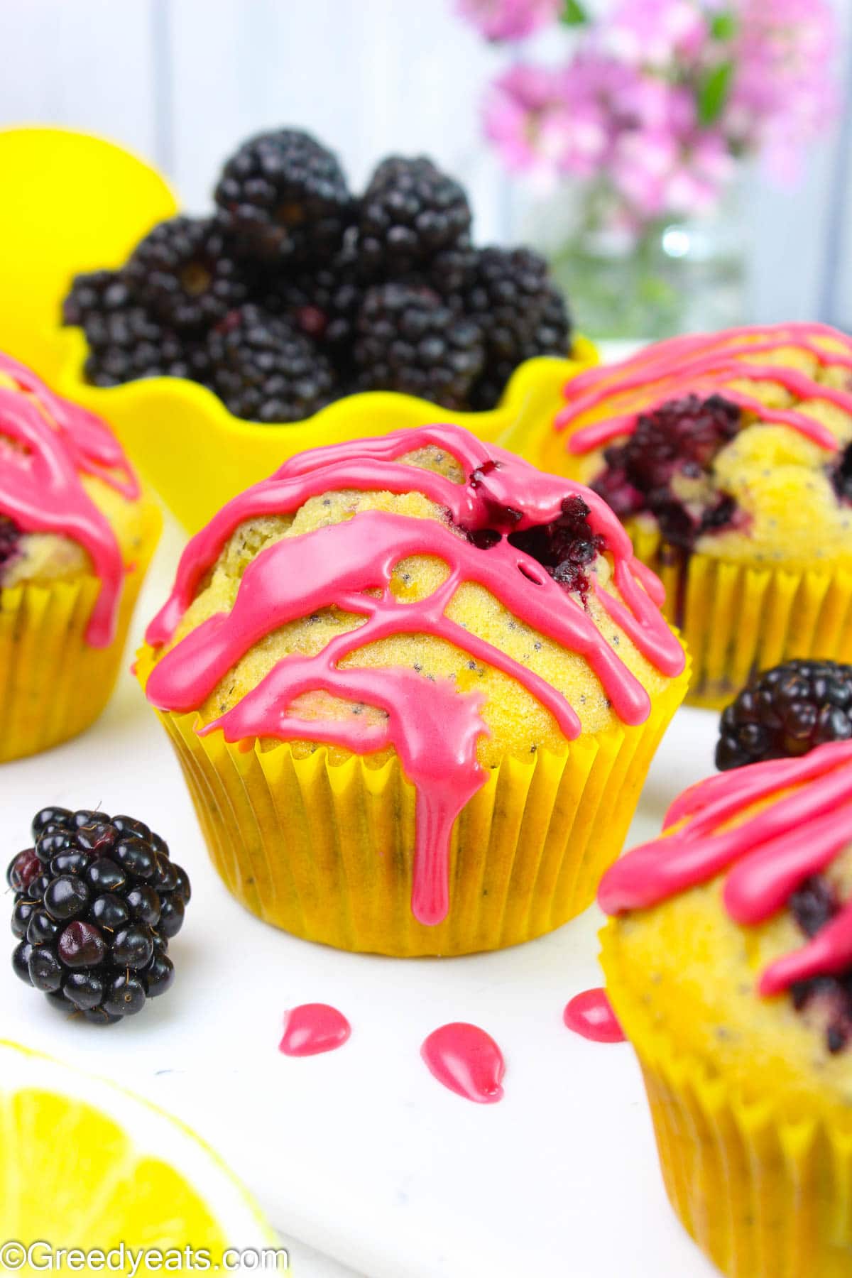 Soft and fluffy Poppyseeds Lemon Blackberry Muffins topped with blackberry glaze