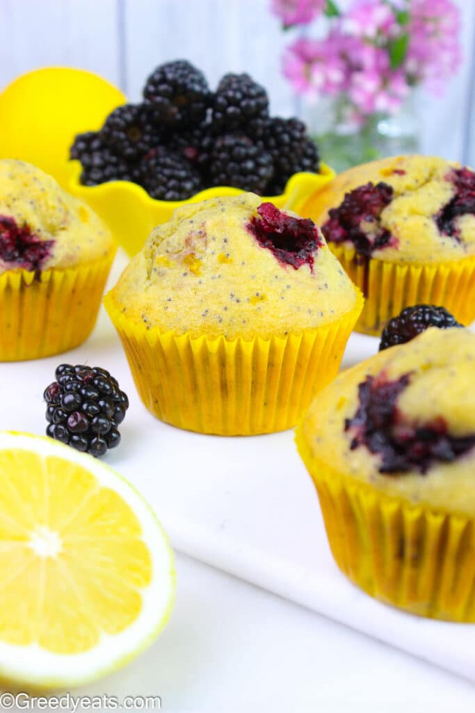 Moist and tall homemade lemon muffins dotted with poppyseeds and fresh berries.