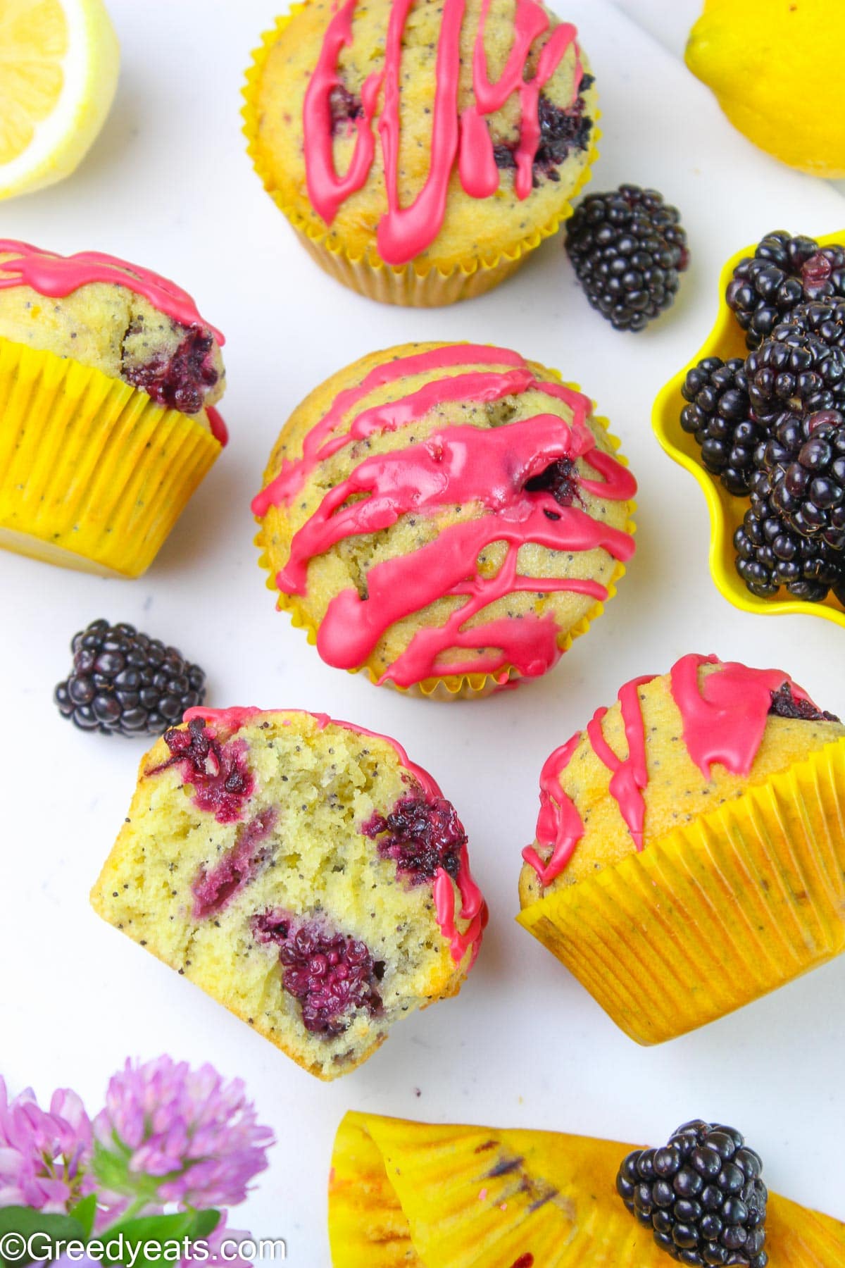 Easy Lemon Muffins topped with fresh and fruity glaze and dotted with poppy seeds and berries.