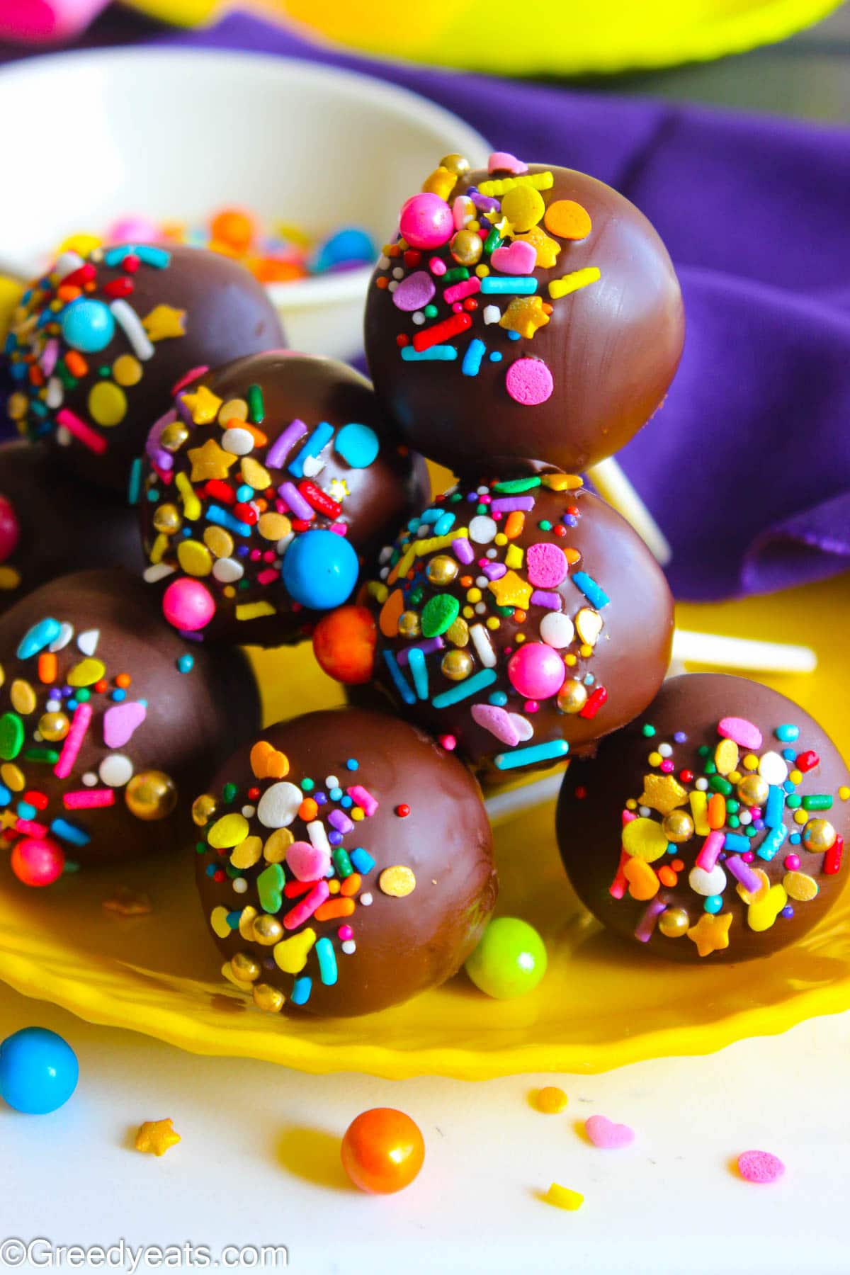 Moist and gooey Chocolate Cake Pops topped with milk chocolate and birthday sprinkles. 