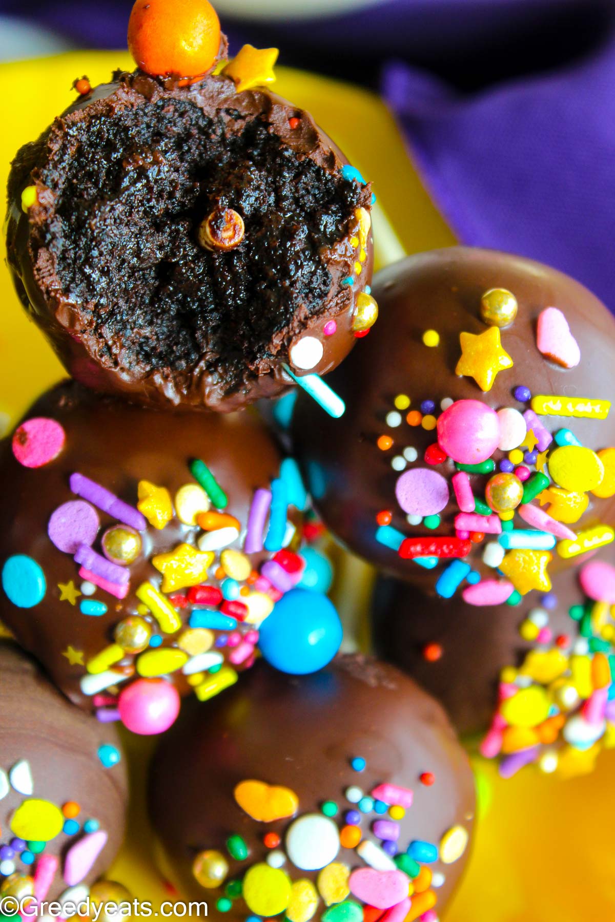 Super moist and decadent chocolate cake pops coated with milk chocolate and topped with sprinkles.