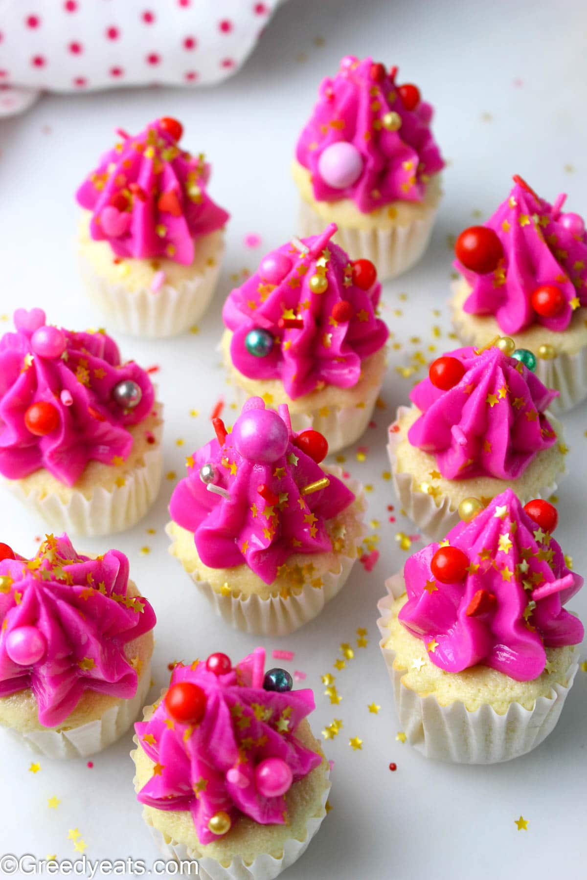 Quick and soft mini cupcakes flavored with vanilla and topped with pink buttercream and sprinkles.