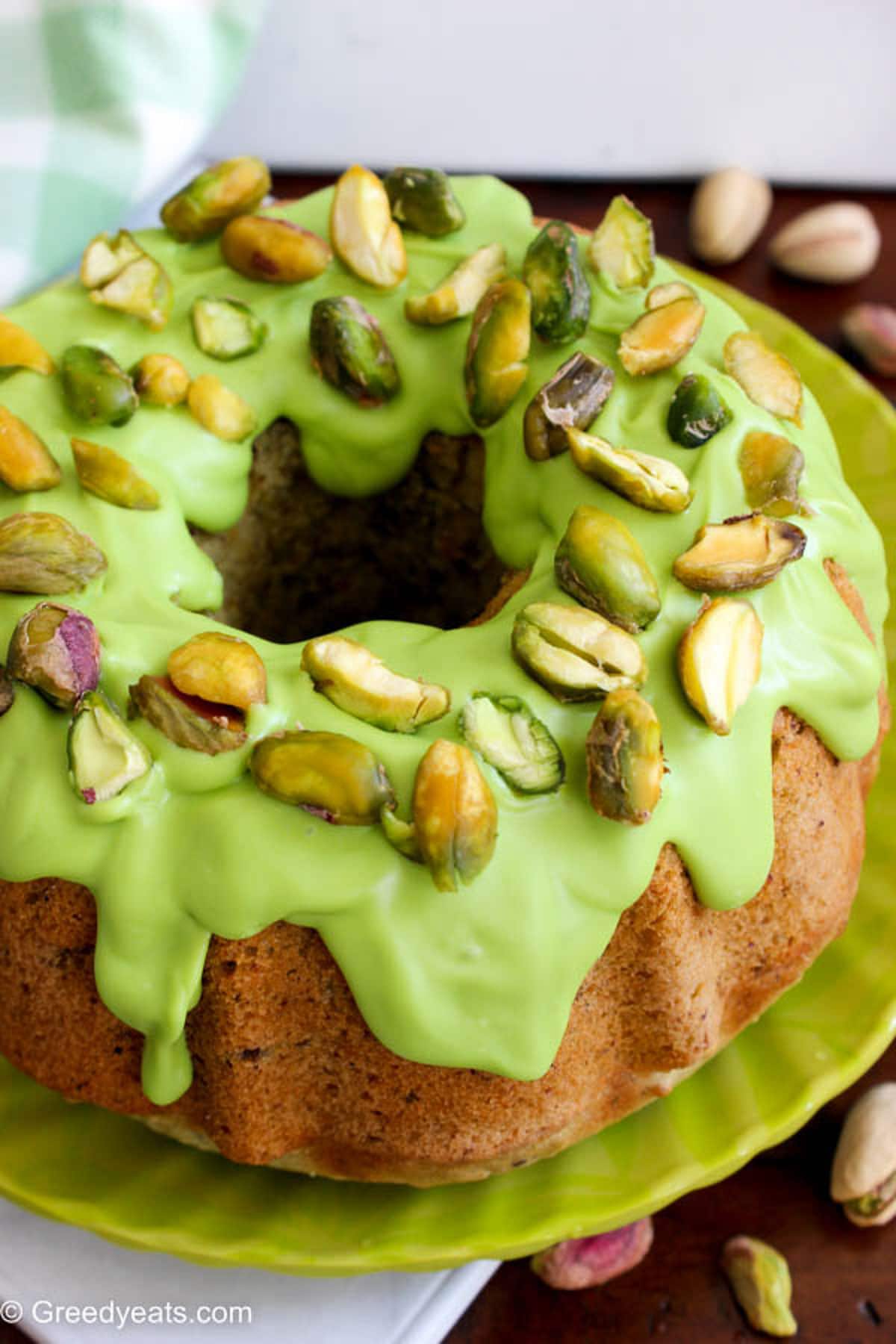 Pistachio bundt cake made in a small bundt pan, topped with light green candy melts topping.