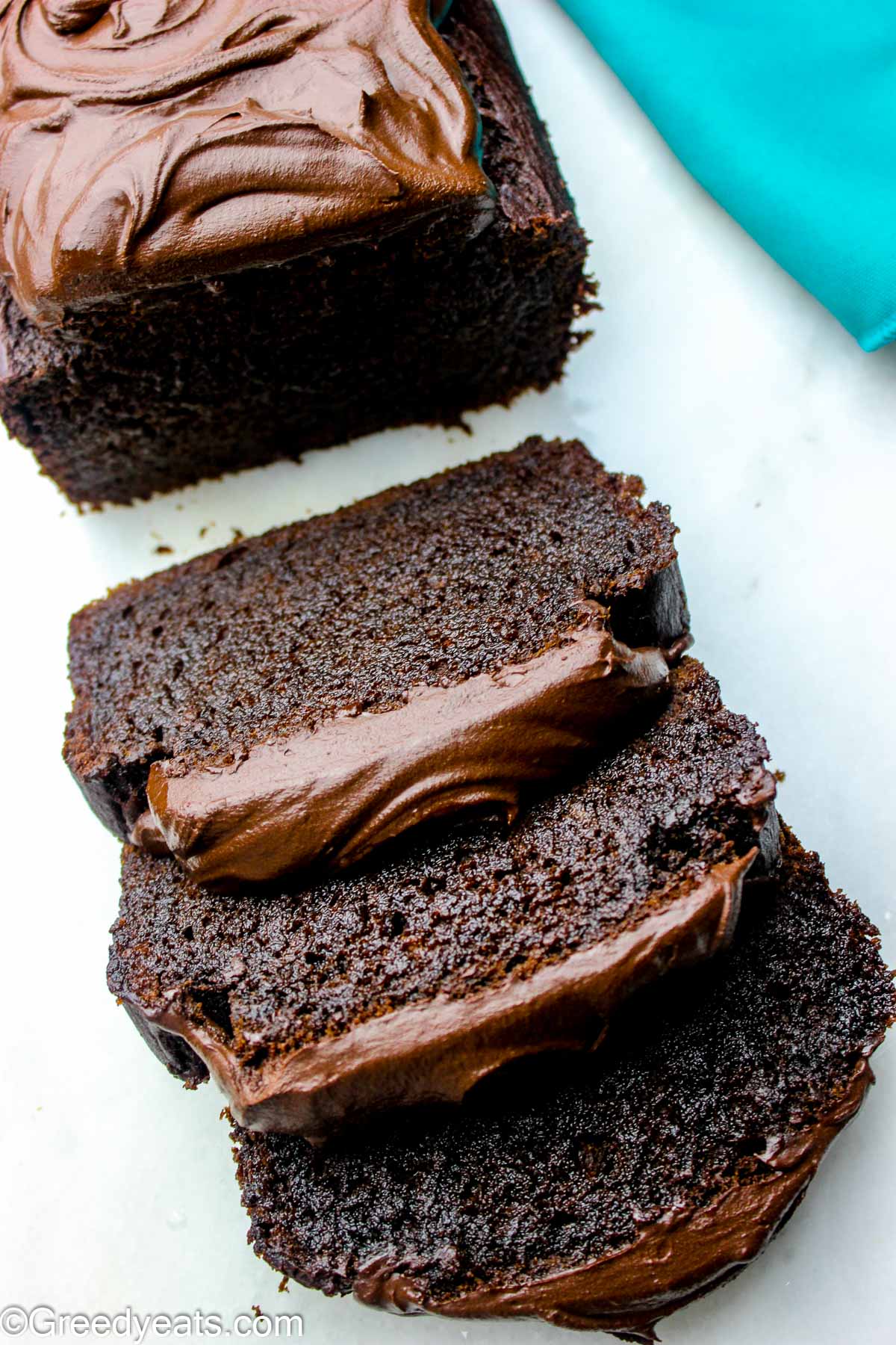 Easy Banana Bread covered with chocolate frosting kept on a white board.