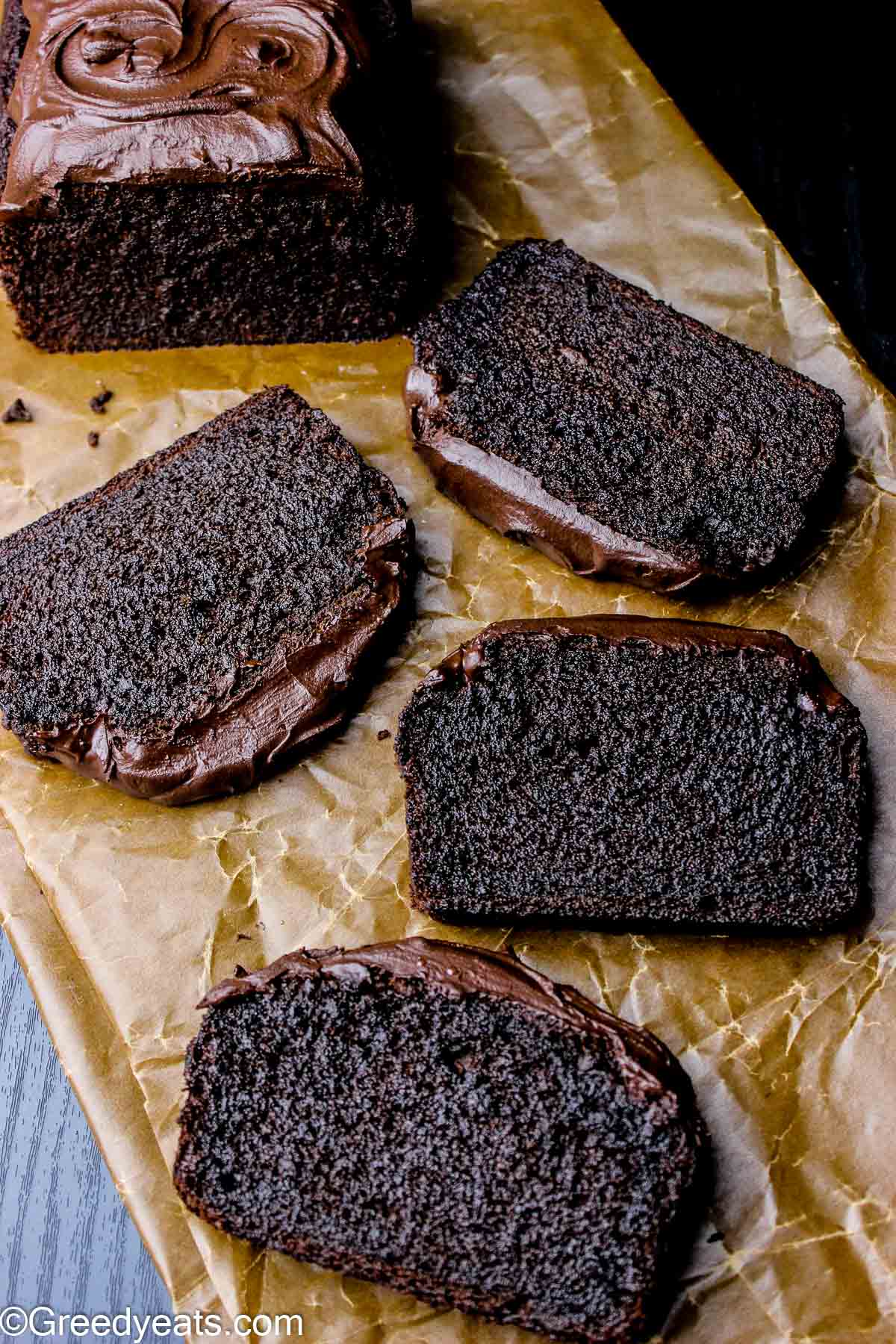 Moist and rich Chocolate Banana Bread slices topped with decadent chocolate frosting .