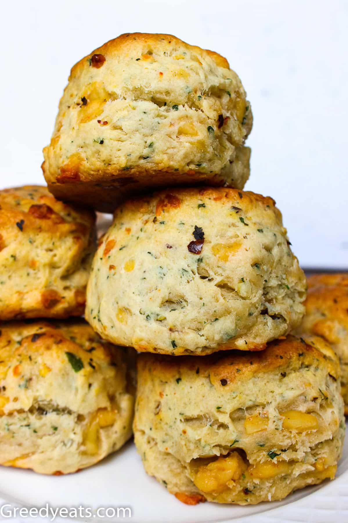 Stack of tall, flaky and buttery Cheese Biscuits infused with garlic, fresh parsley and chili flakes.