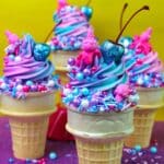 Ice cream cone cupcakes with vanilla buttercream frosting, sprinkles and a glitter cherry on top.