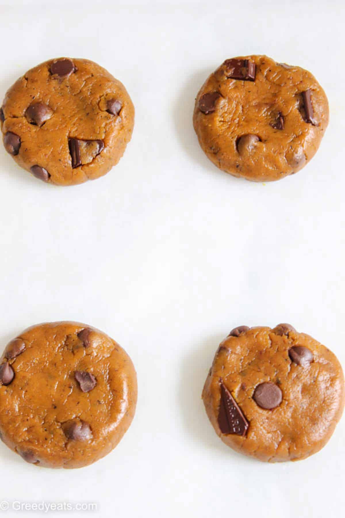 Pumpkin Cookie dough balls flattened before baking to allow them to spread as cookies bake.