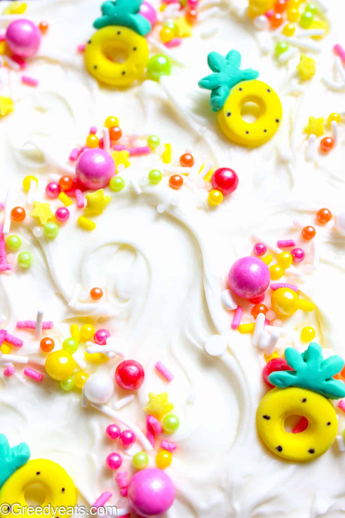 Light and creamy, tangy and sweet cream cheese frosting recipe topped with pink and yellow summer themed sprinkles.