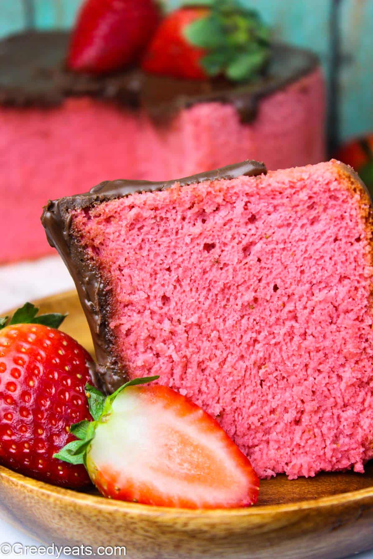 A slice of moist Strawberry Chiffon Cake topped with Chocolate Ganache and fresh strawberries.