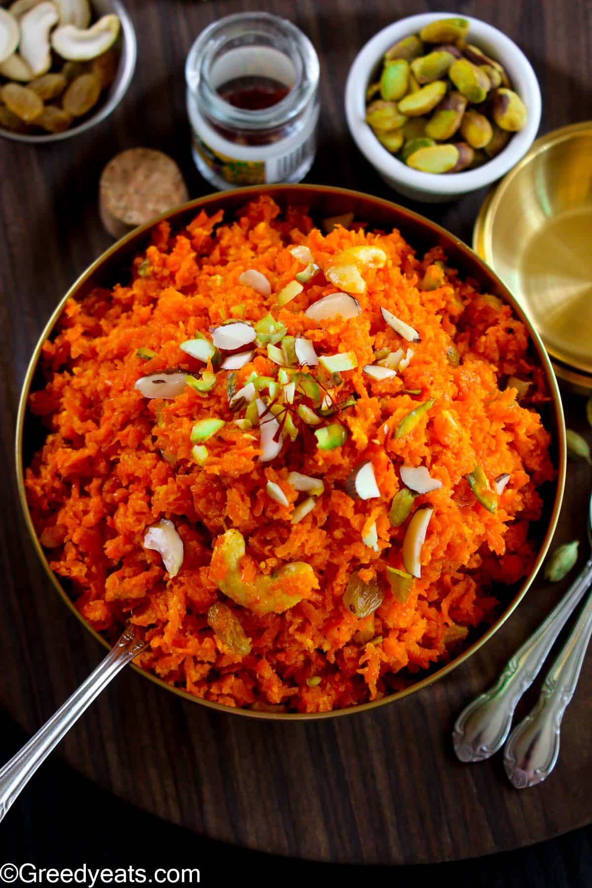 Gajar ka Halwa served in a bowl, topped with nuts like almonds, pistachios, raisins and cashews. 