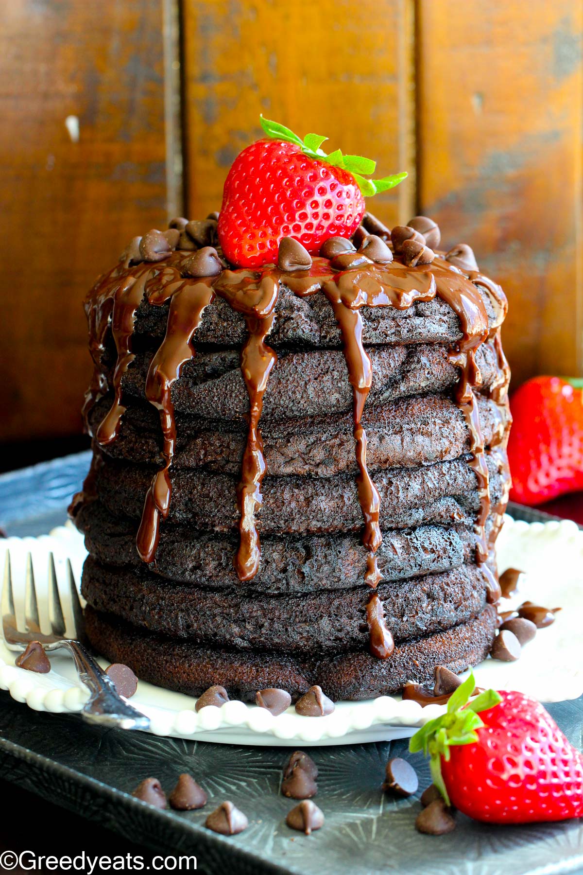 Fluffy and soft Chocolate Pancakes served with hot chocolate ganache and fresh strawberries.