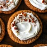 Easy and chewy on the edges Carrot Cake Cookies topped with cream cheese frosting and chopped nuts.
